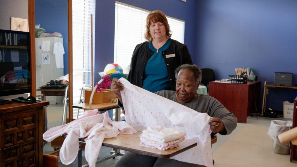 a woman folding laundry as part of a memory care service at Chapel Woods